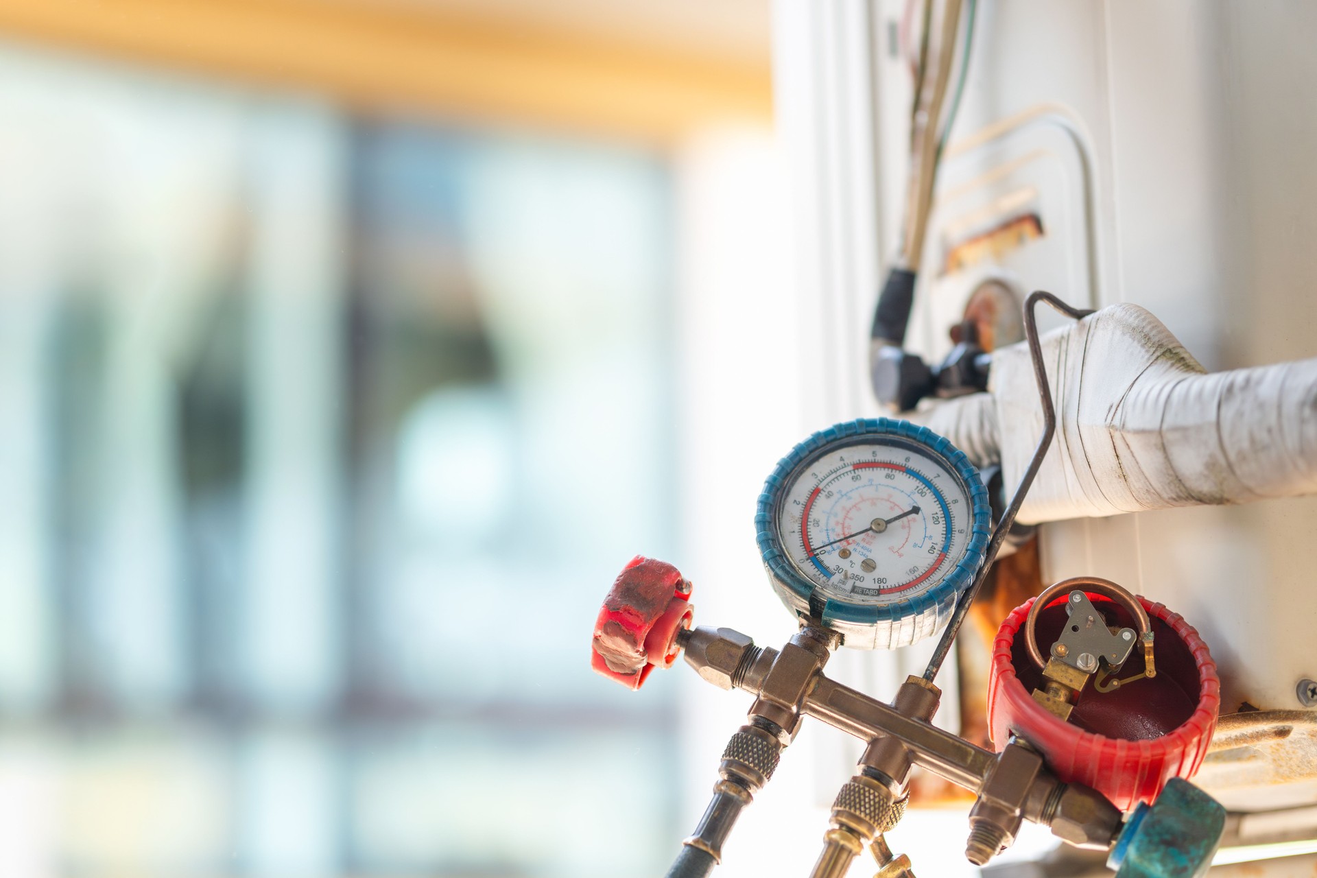 HVAC service technician using manifold gauge to check refrigerant, Air Conditioning Repair